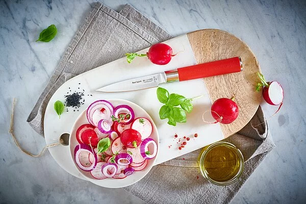 Red Spirt paring knife with plate of veggies